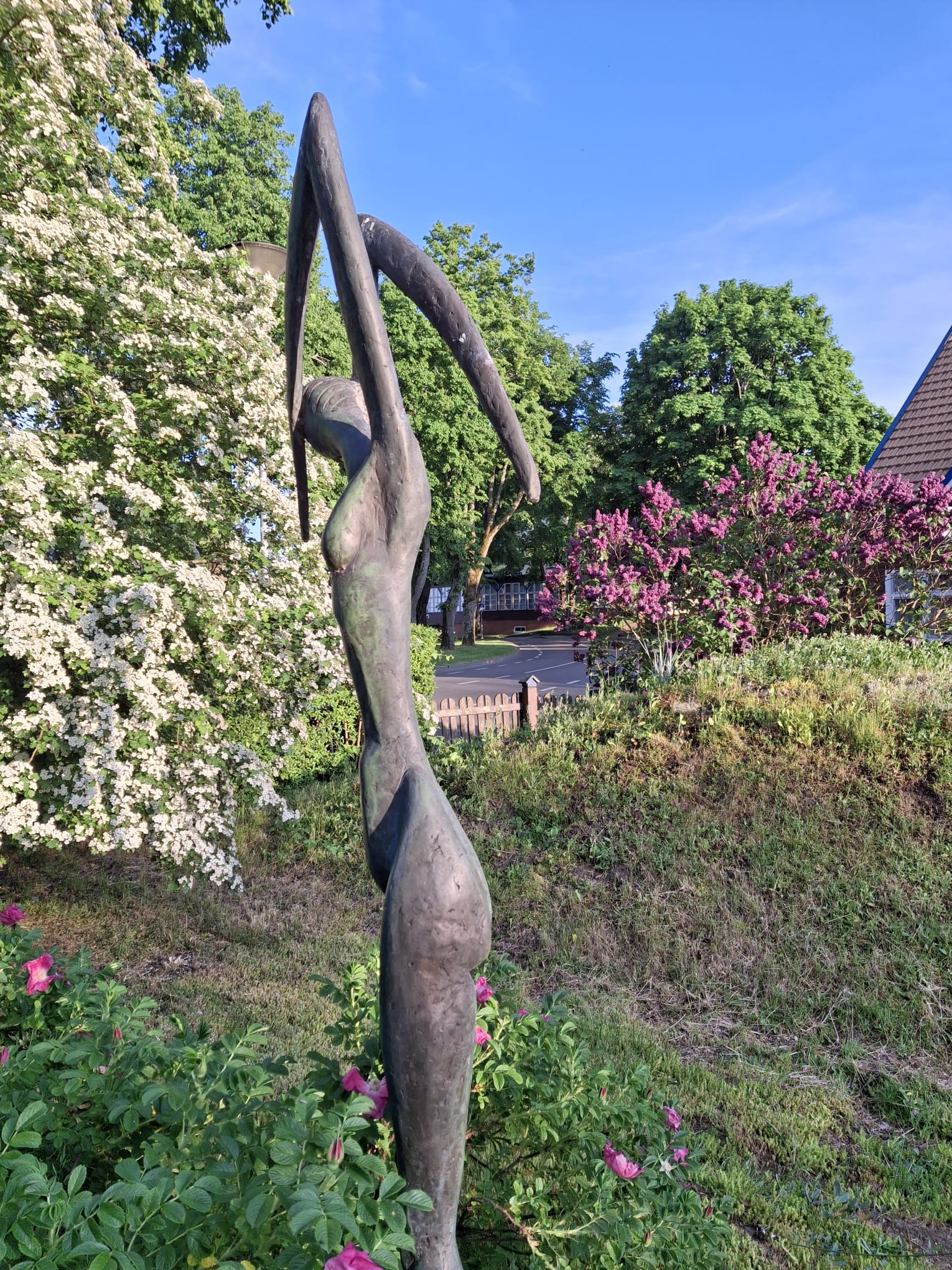 Skulptur und blühender Garten am Haus Aika